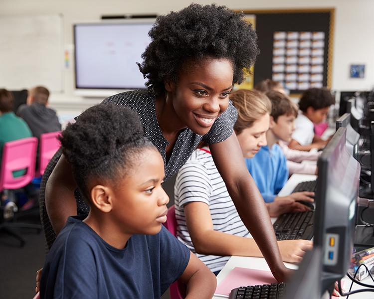 Teacher helping student at desk