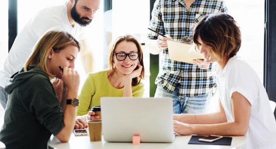 Retail marketers brainstorming together using a laptop