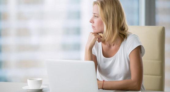 Woman looking worried as she waits for a response from jobs she has applied to