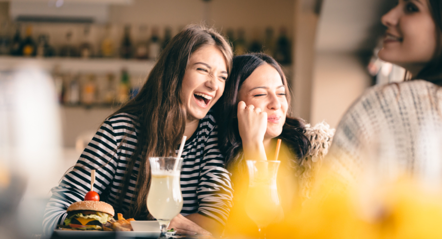 two friends smiling and enjoy food together
