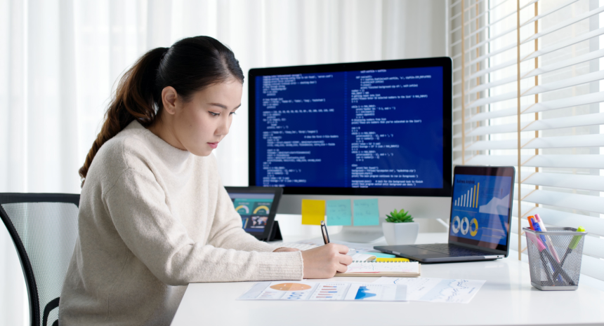 professional woman writing notes at her desk