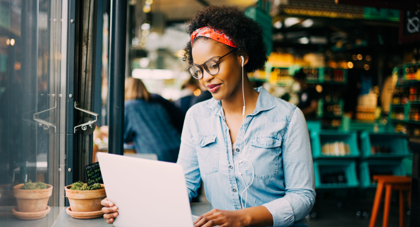 Confident worker improving resume on laptop in trendy cafe.