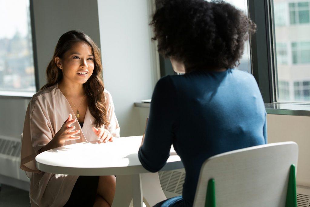 two professionals sitting face to face at table