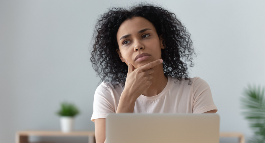 Curious professional at laptop wondering how to write a letter of intent.