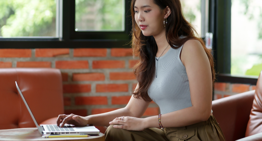 Young woman working on cover letter on laptop.