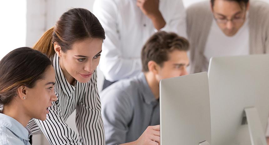 Two female coworkers collaborating at a computer