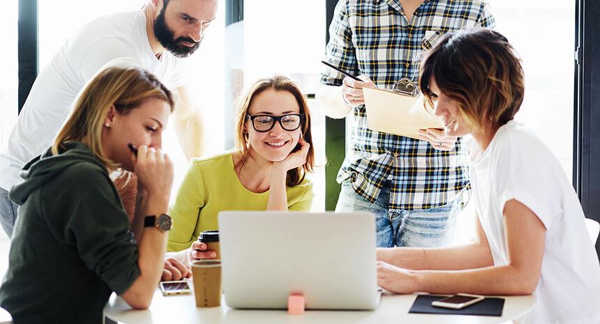Retail marketers brainstorming together using a laptop