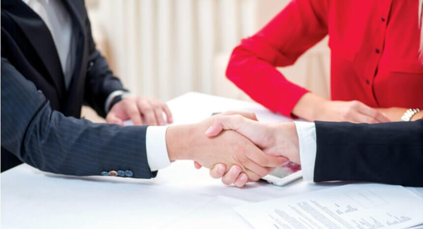 Three successful and confident businesspeople shake hands