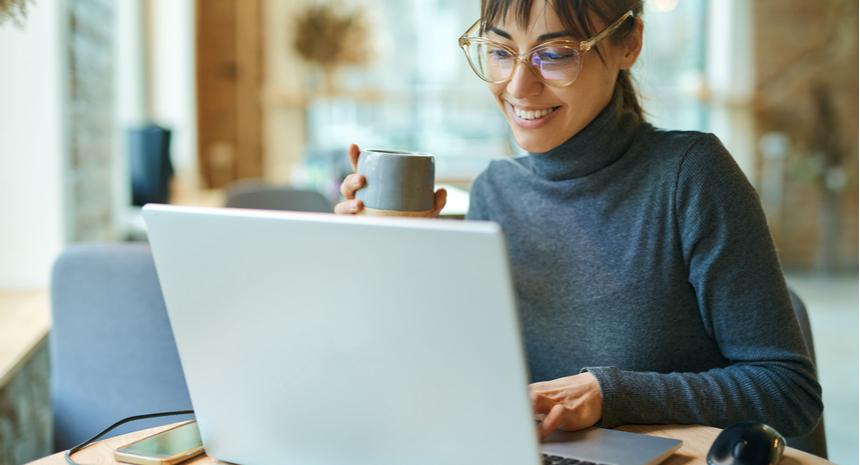 Woman smiling while looking into her laptop screen