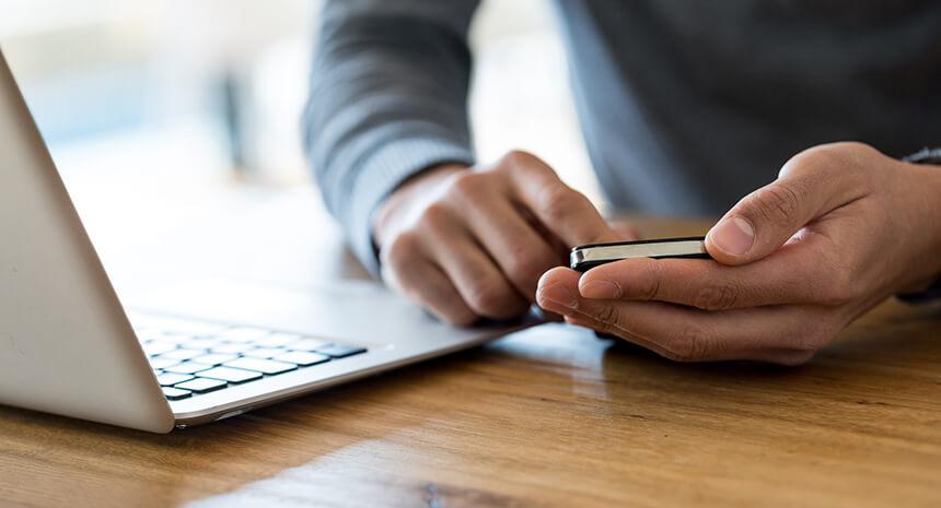 Man checking his phone for a response from a Job he applied to