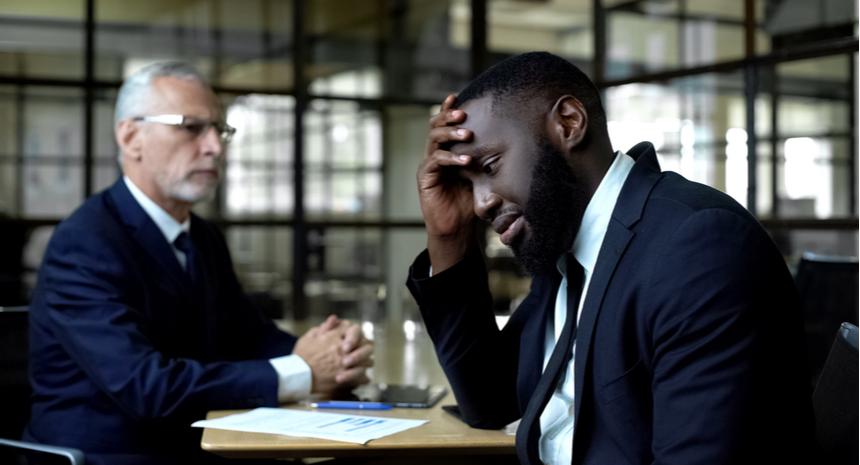 Man looking worried as his boss glances over at him