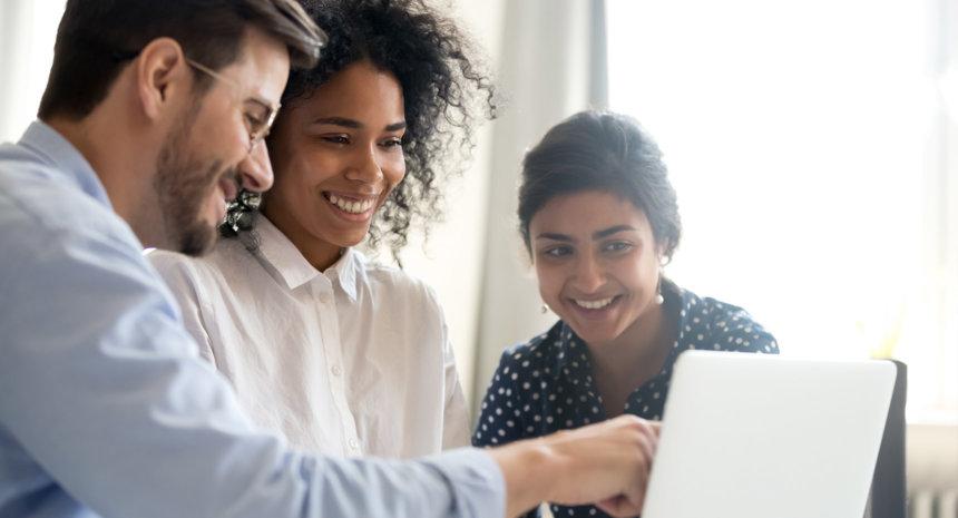 Group of people smiling looking at laptop