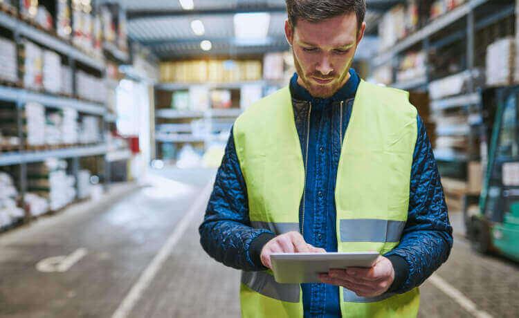 Man working in a warehouse using a tablet